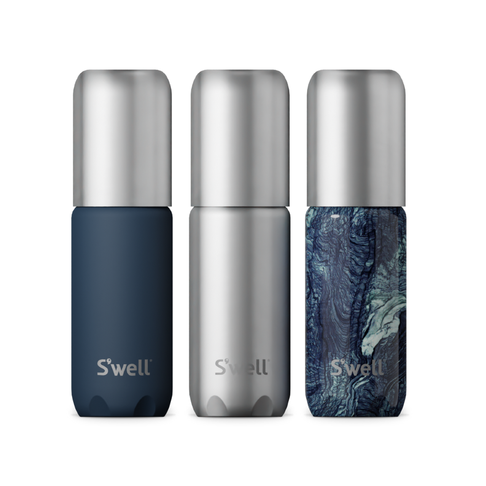 Close-up of the Azurite Marble, silver, and navy travel bottles with leak-free pumps.
