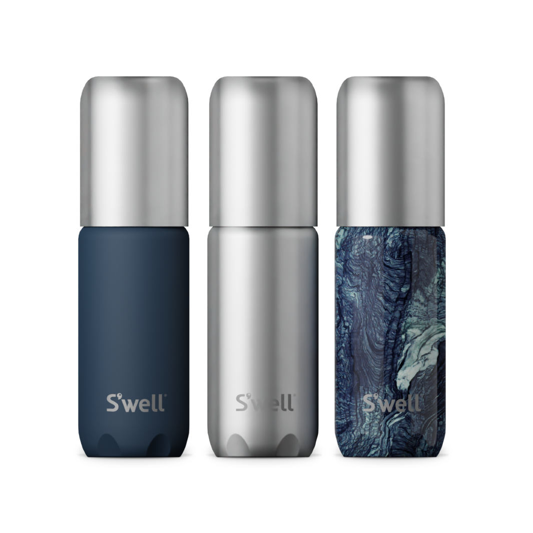 Close-up of the Azurite Marble, silver, and navy travel bottles with leak-free pumps.