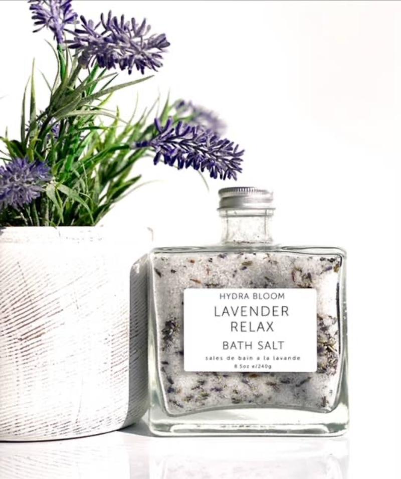 Close-up view of the Lavender Relax Bath Salts, showcasing the Epsom and Dead Sea salts mixed with organic lavender flowers next to lavender plant.