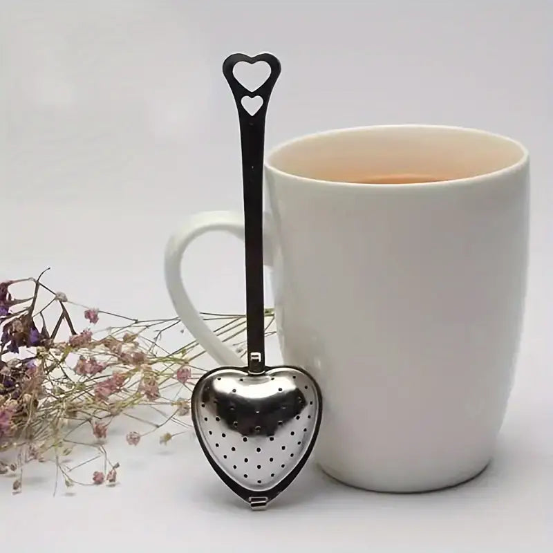 Heart-shaped stainless steel tea strainer elegantly displayed for loose-leaf tea.