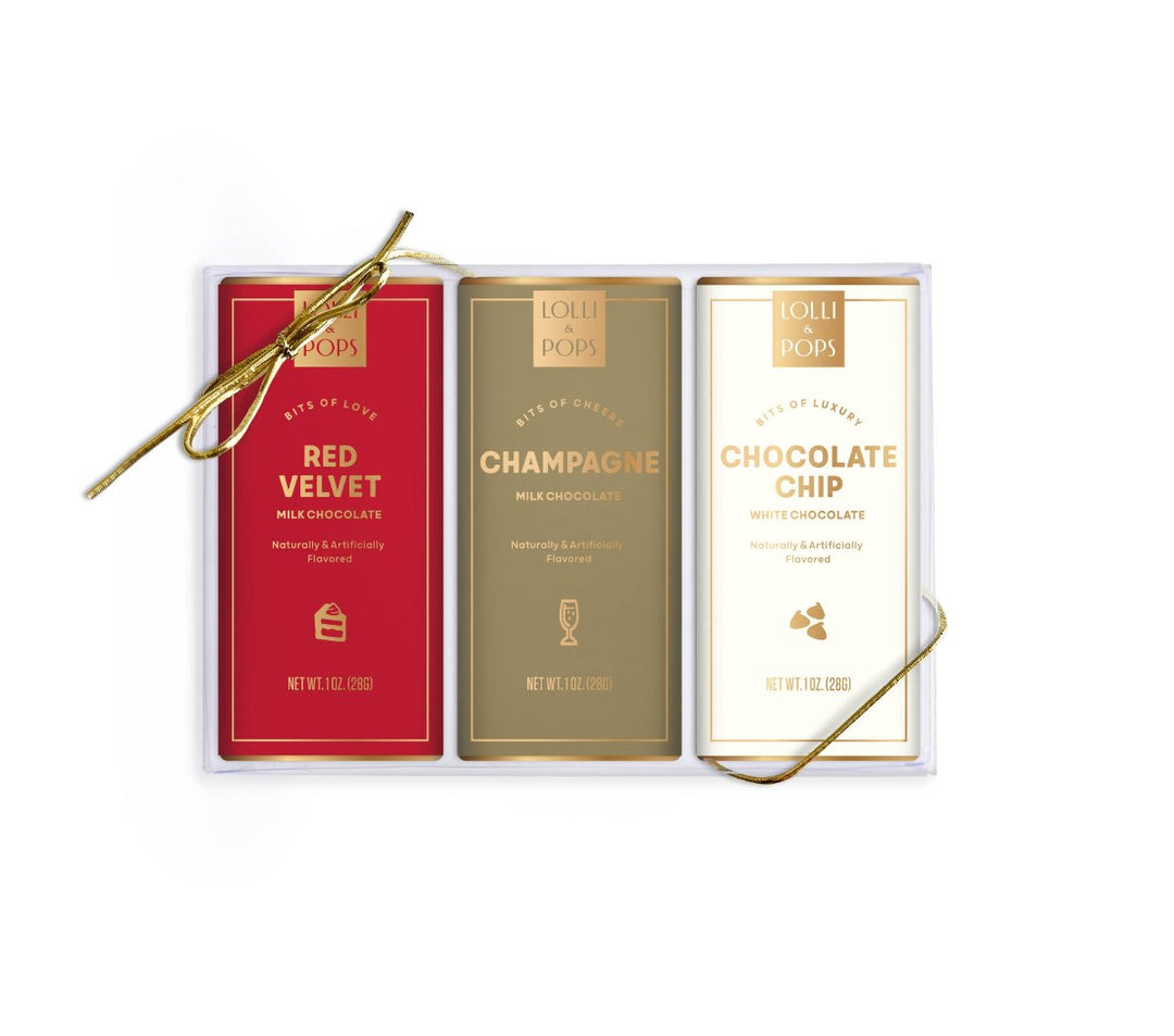 Holiday Decadent Bar Set includes Red Velvet, Champagne, and Chocolate Chip White Chocolate bars in a gift box with gold bow. 