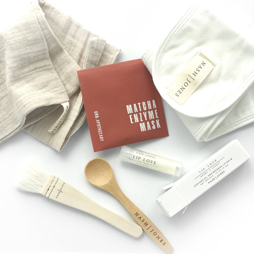 Close-up view of Matcha Mask powder and accessories including bamboo spoon, headband, and application brush.