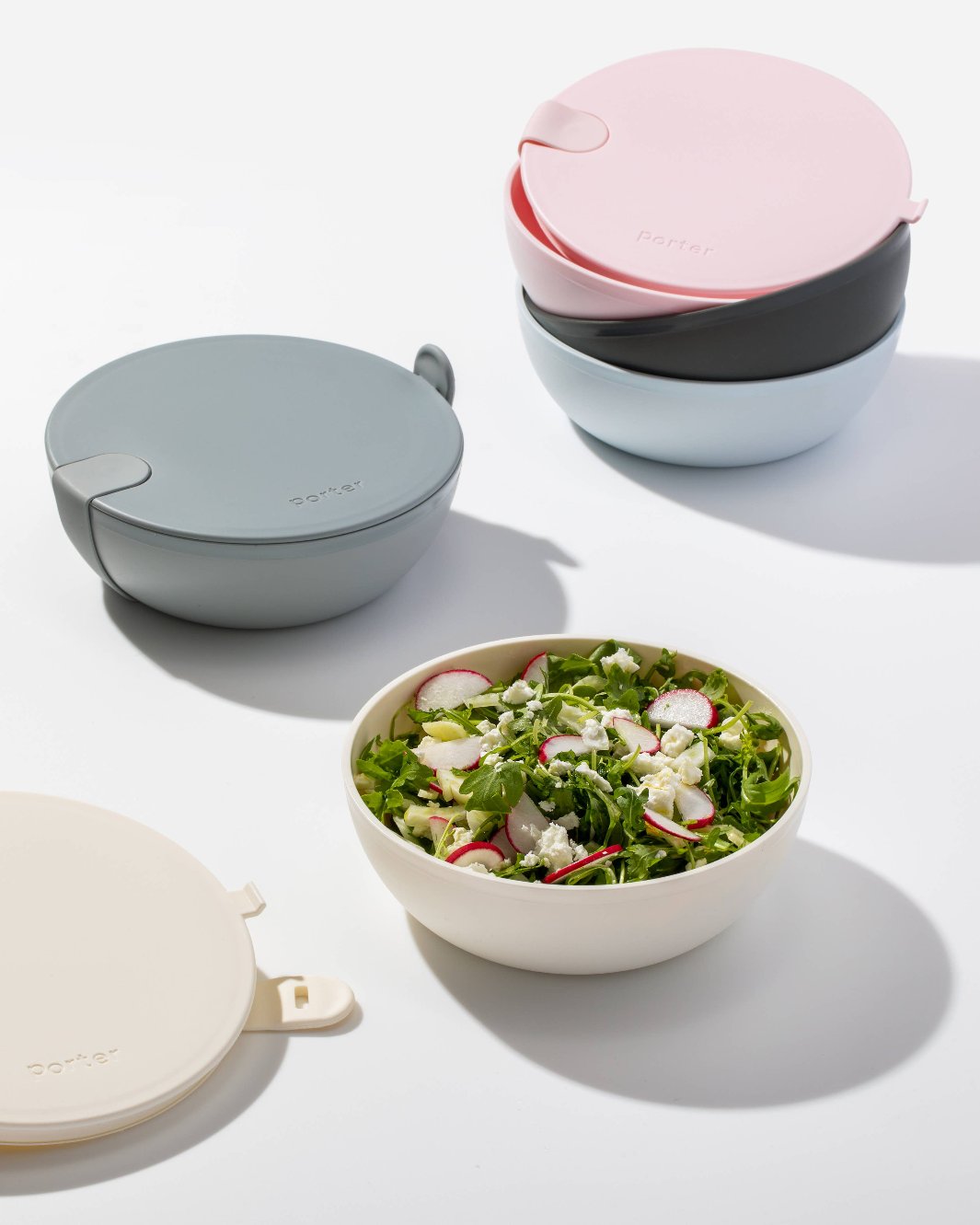 Porter Lunch Bowls with silicone strap securing the lid and filled with a fresh salad, displayed on a countertop
