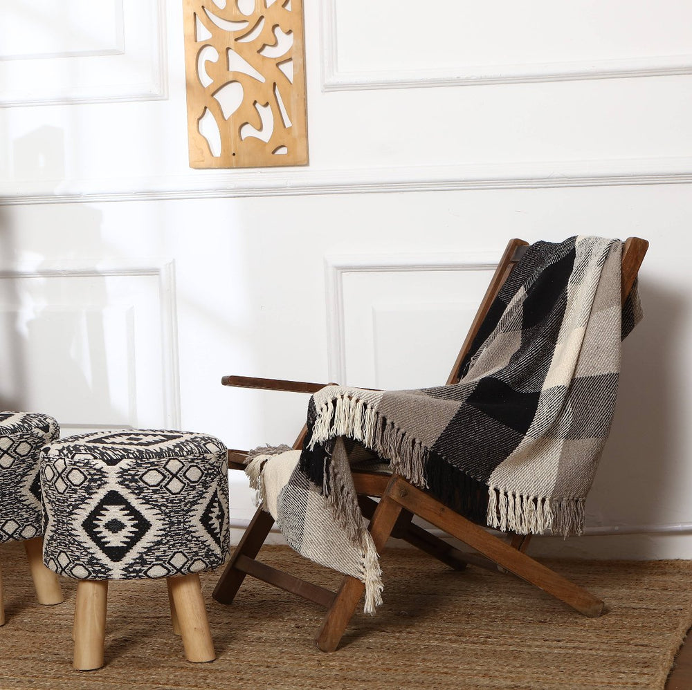 Black & Grey Plaid Throw Blanket draped over a chair, showcasing its classic design.