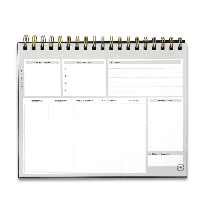 Stay on Track Notepad opened flat, displaying the structured weekly layout with space for daily tasks, projects, notes and goals.