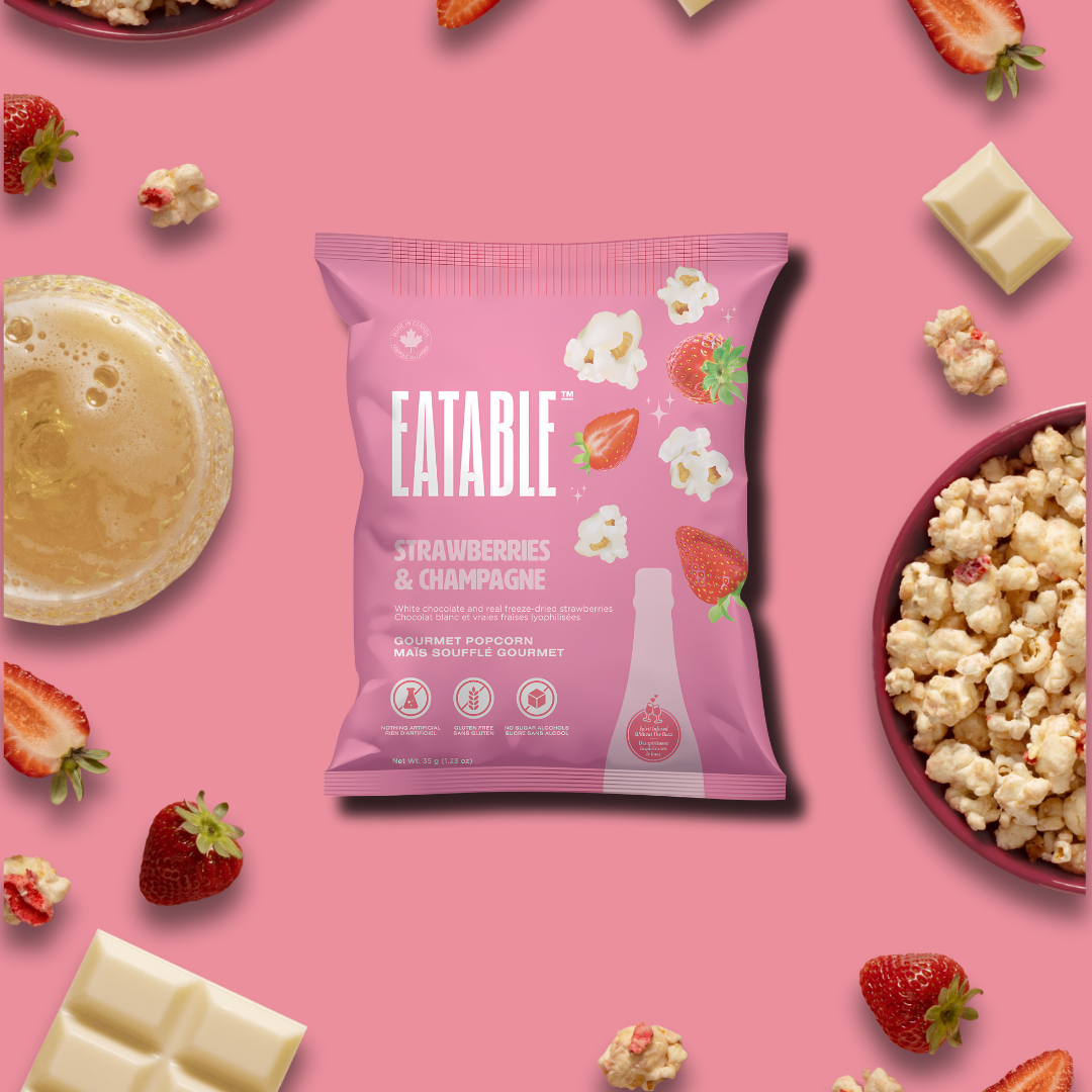 Mini bag of gourmet Strawberries & Champagne Popcorn displayed with a festive backdrop.