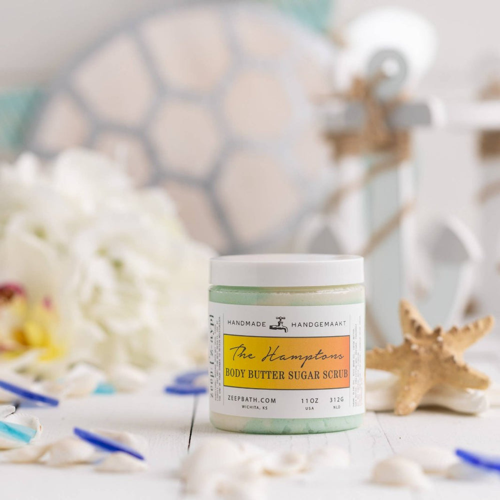 Jar of The Hamptons Body Butter Sugar Scrub, a luxurious exfoliating and moisturizing product with ocean mist, oud wood, and amber scent.