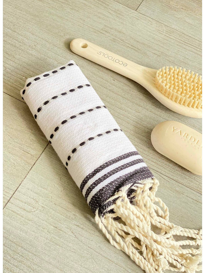 Elegant white guest towel with black stitches, made of durable cotton fibers, adding sophistication to any space. 