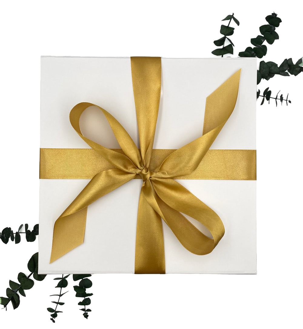 World of Gifting white magnetic close keepsake gift box adorned with gold satin ribbon.